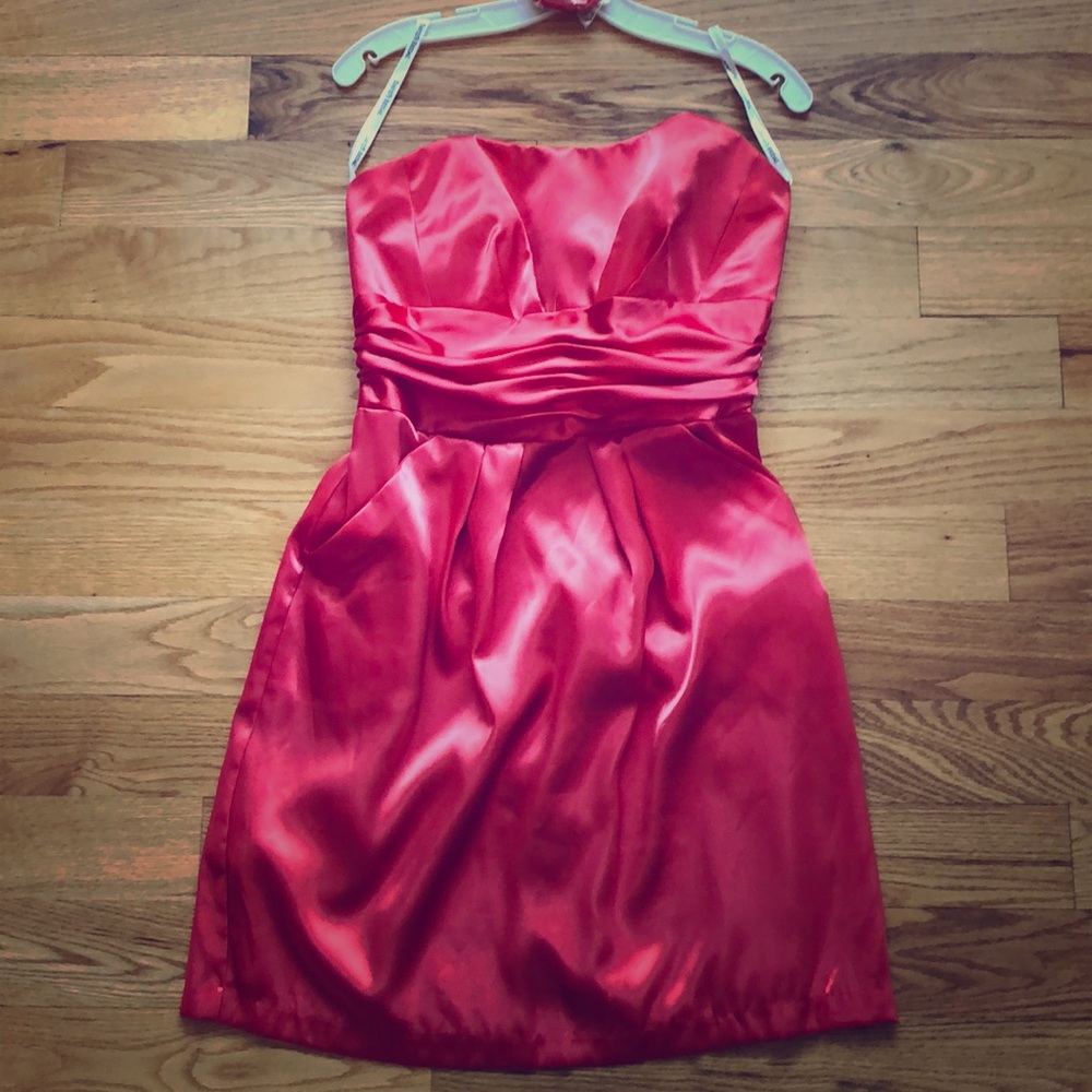 Coral satin strapless dress with pockets.